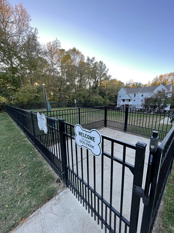 a black fence with a white house in the background
